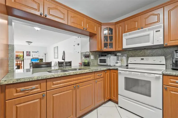 a kitchen with granite countertop a sink stainless steel appliances and cabinets