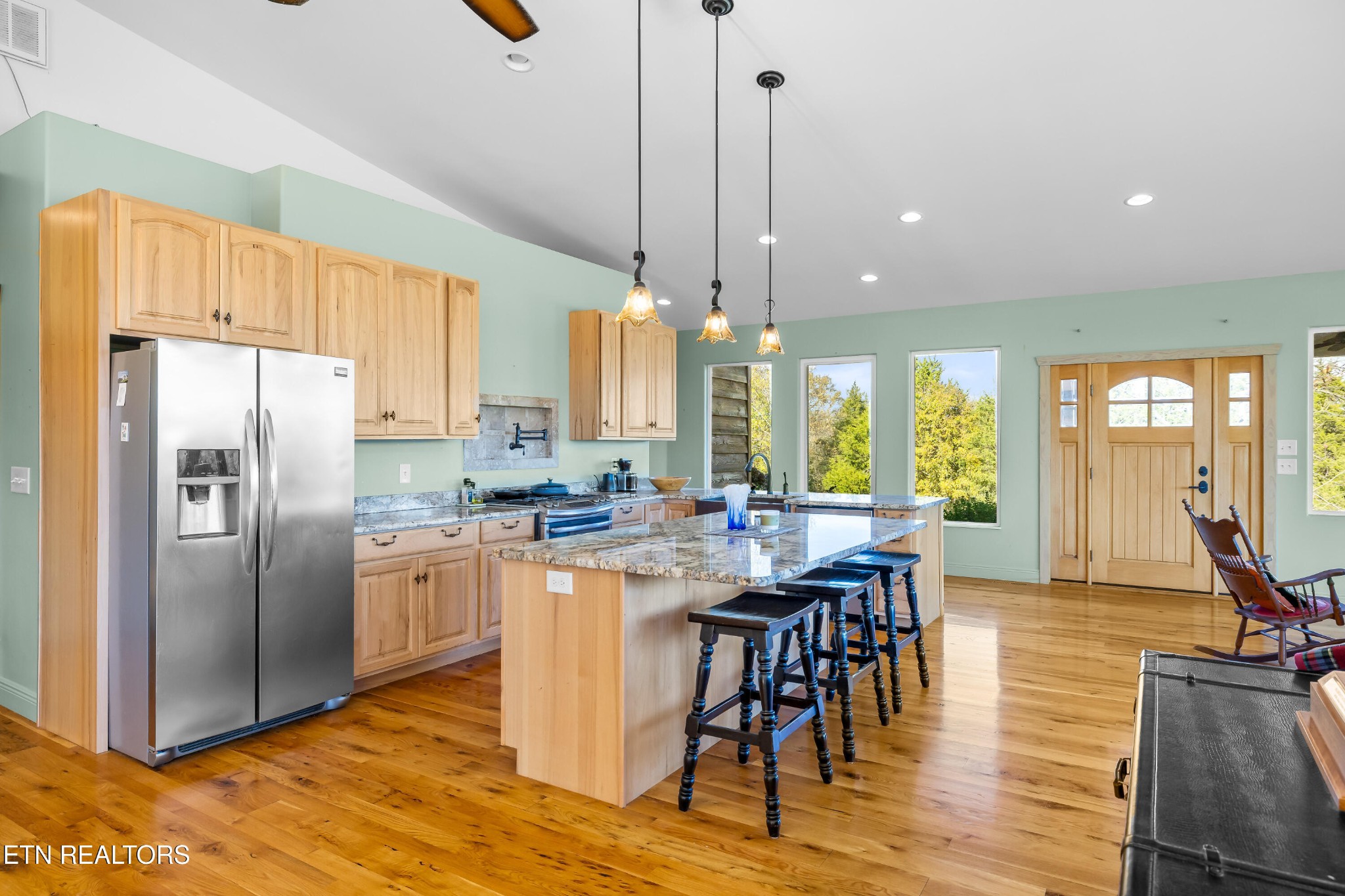 3070 West Fork Road Loudon, TN 37774 - Photo 12 of 48 a kitchen with stainless steel appliances granite countertop a stove top oven a refrigerator a sink a dining table and chairs with wooden floor
