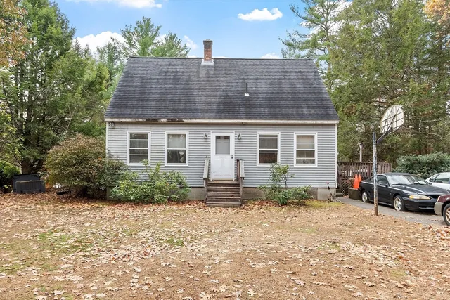 a front view of house with yard and trees around