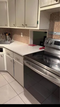 a kitchen with a stove and white cabinets