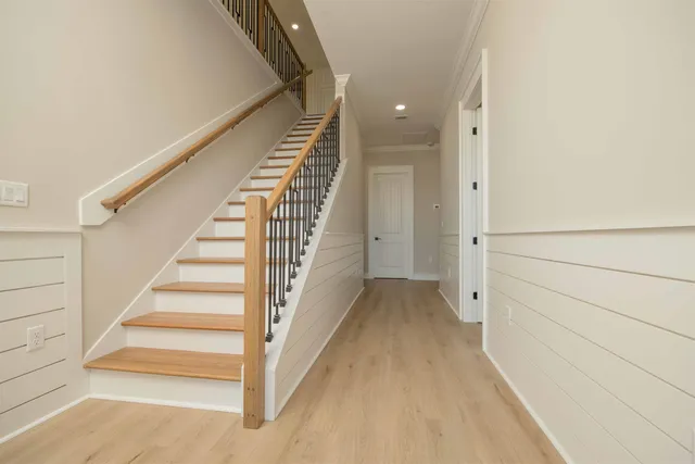 a view of a dining room and livingroom with furniture wooden floor a chandelier