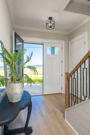 a kitchen with stainless steel appliances kitchen island granite countertop a refrigerator a stove a dining table and chairs with wooden floor
