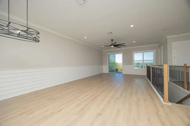 a view of empty room with wooden floor and window