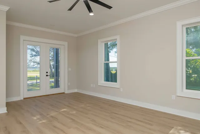 an empty room with a ceiling fan and wooden floor