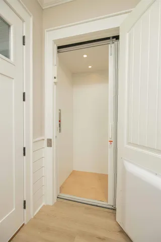 a kitchen with a sink dishwasher and white cabinets with wooden floor