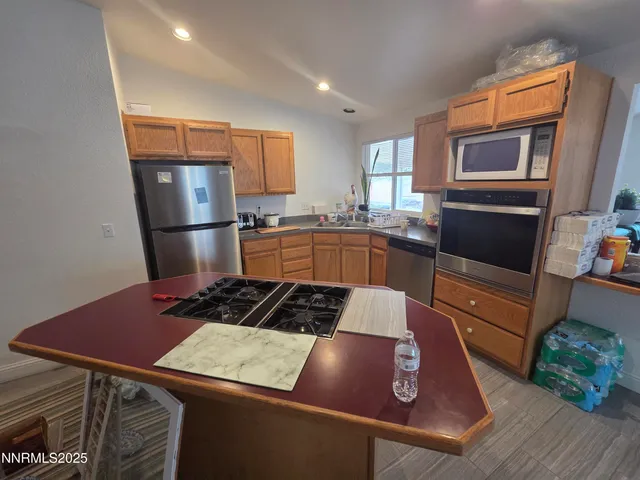 a kitchen with a refrigerator and a stove top oven