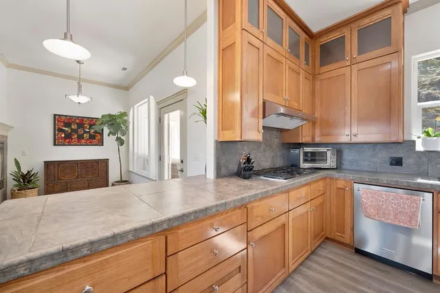 a kitchen with stainless steel appliances granite countertop a sink a stove and cabinets