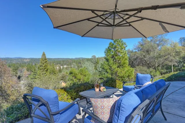 a view of a balcony with chairs and an umbrella