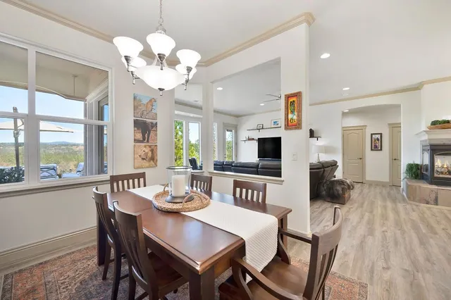 a view of a dining room with furniture a chandelier and wooden floor
