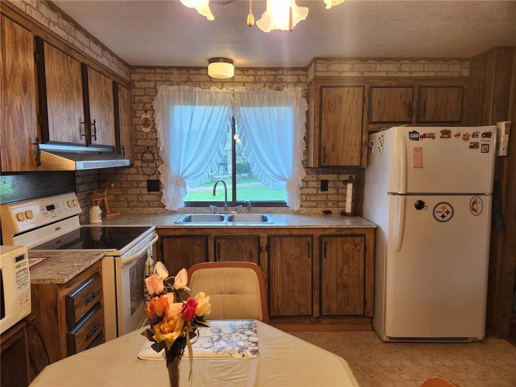 935 Rockdale Road Butler, PA 16002 - Photo 8 of 34 a kitchen with a refrigerator a stove a sink and cabinets