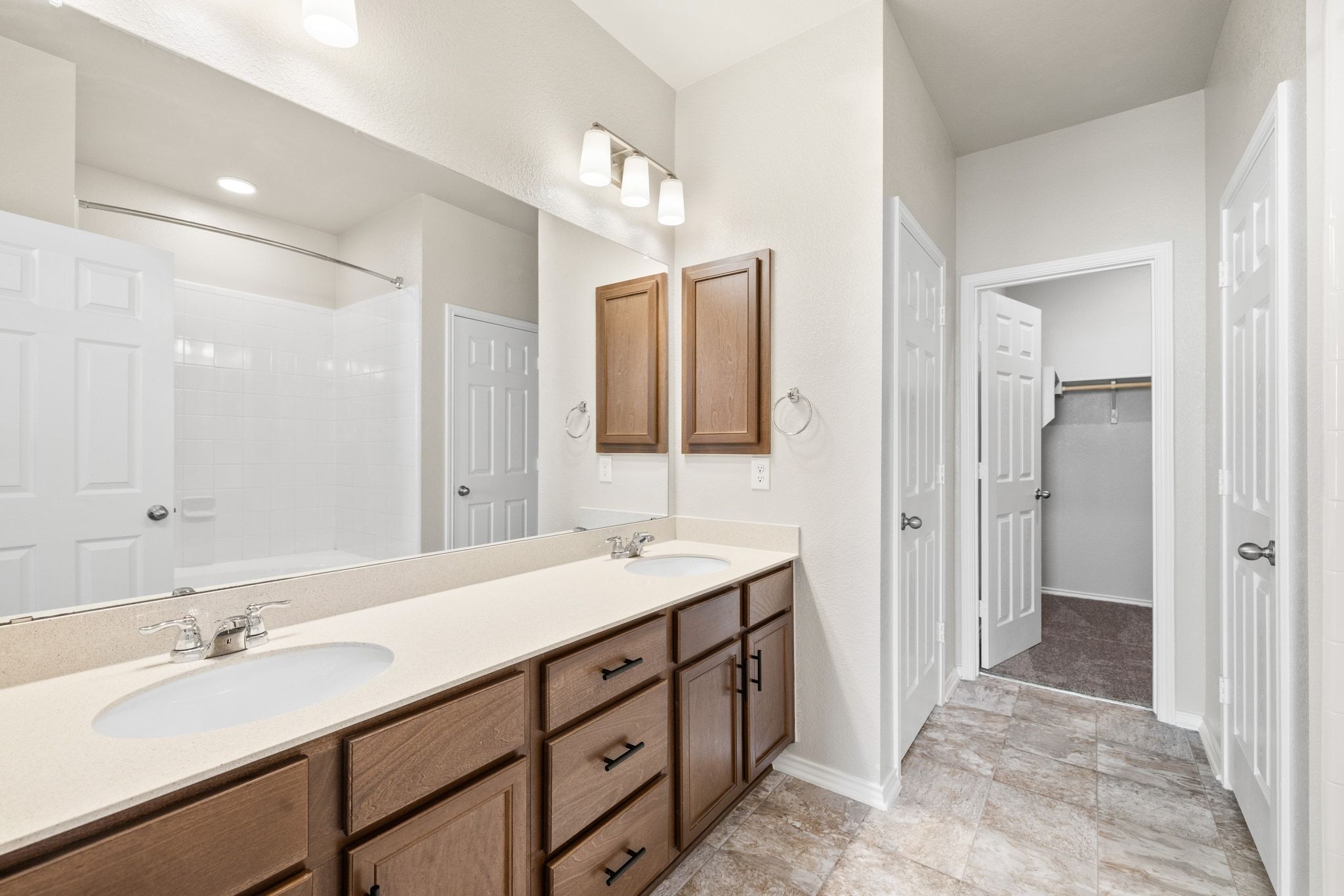1829 Stringer Pass Leander, TX 78641 - Photo 16 of 36 Full bathroom with double vanity, a walk in closet, and washtub / shower combination