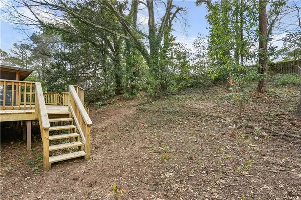 a view of a backyard with lawn chairs and iron fence