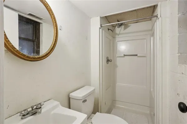 a bathroom with a toilet and a mirror