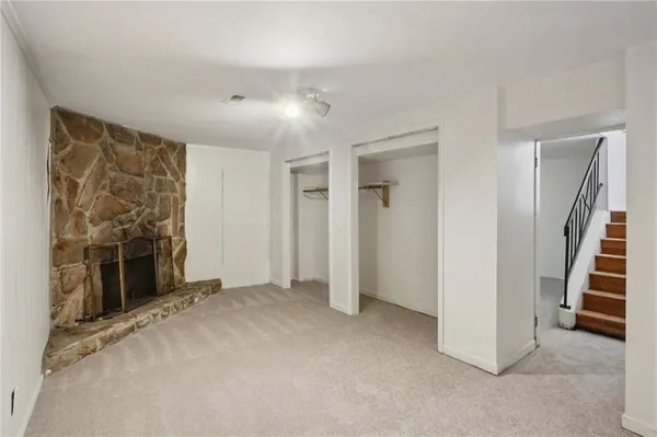 an empty room with fireplace and windows