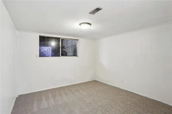 an empty room with a bathroom and mirror