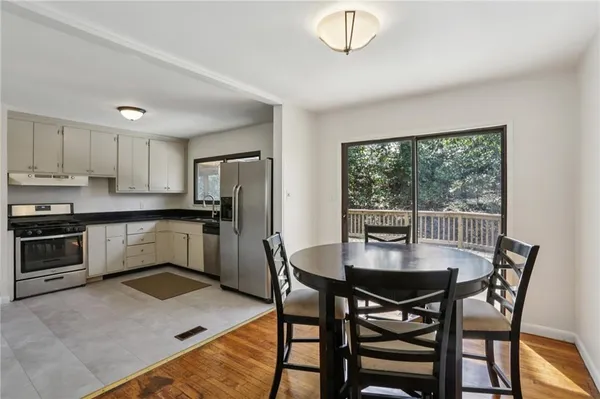 a kitchen with a table chairs microwave and refrigerator