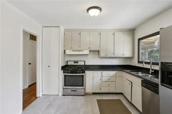 a kitchen with stainless steel appliances granite countertop a stove a sink and a refrigerator