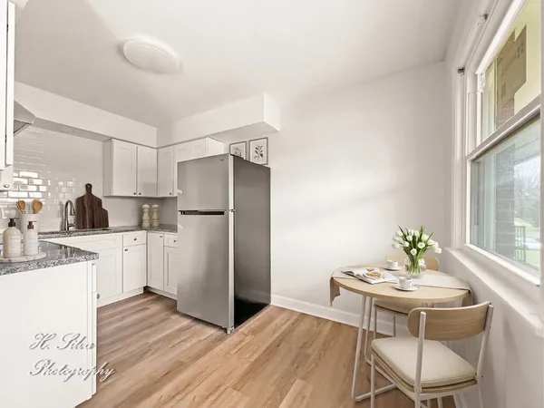 a kitchen with a refrigerator and a dining table