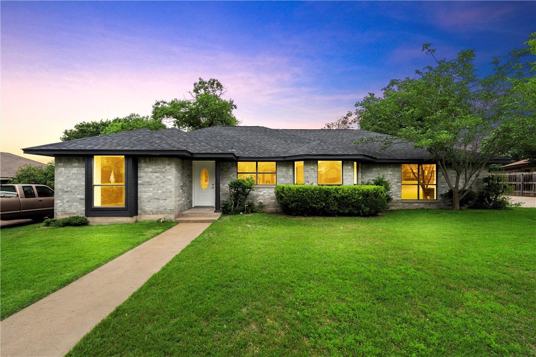 a front view of a house with a garden