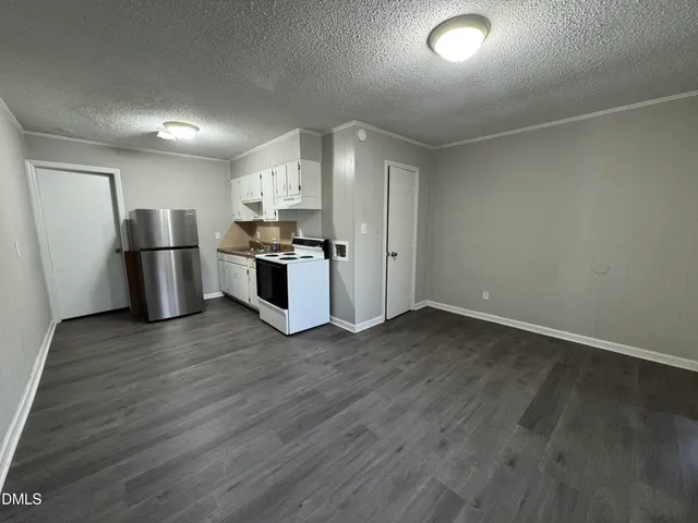 a view of a kitchen with a sink and a refrigerator