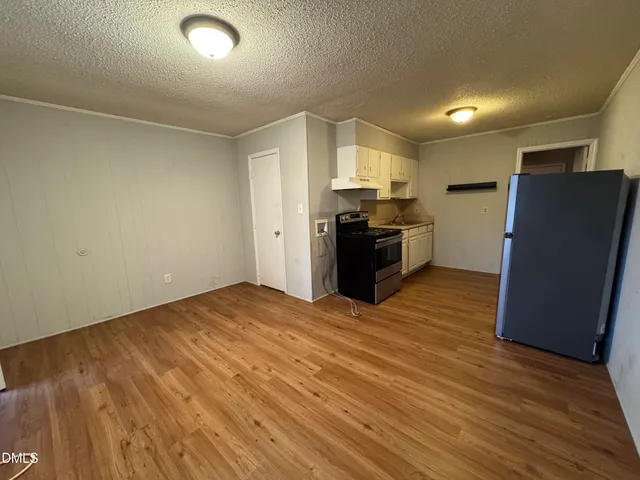 a view of a kitchen with a sink and a refrigerator