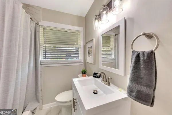 a bathroom with a sink a toilet and a window