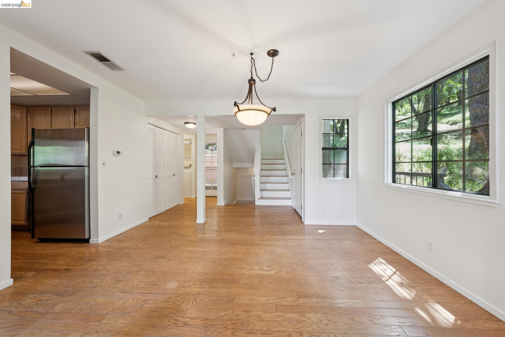 261 Redhawk Road Novato, CA 94949 - Photo 16 of 44 Expansive living area featuring wood-finish flooring, a contemporary ceiling light fixture, and multiple windows
