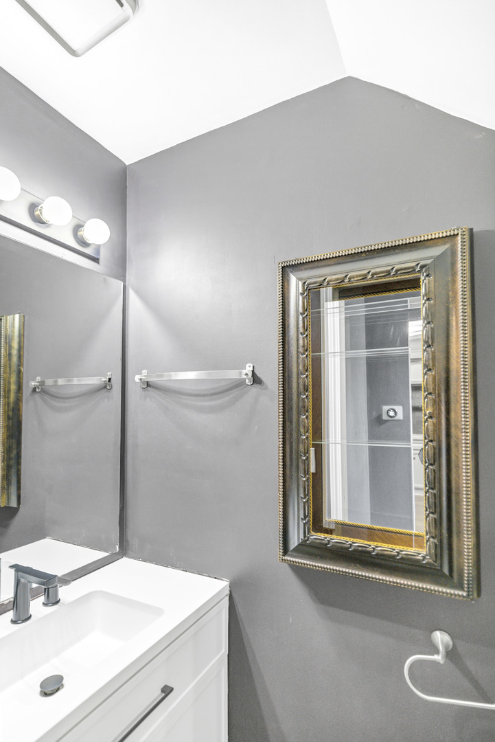 1941 Quaker Hollow Lane, Unit 1941 Streamwood, IL 60107 - Photo 7 of 13 a bathroom with a sink a vanity and a mirror