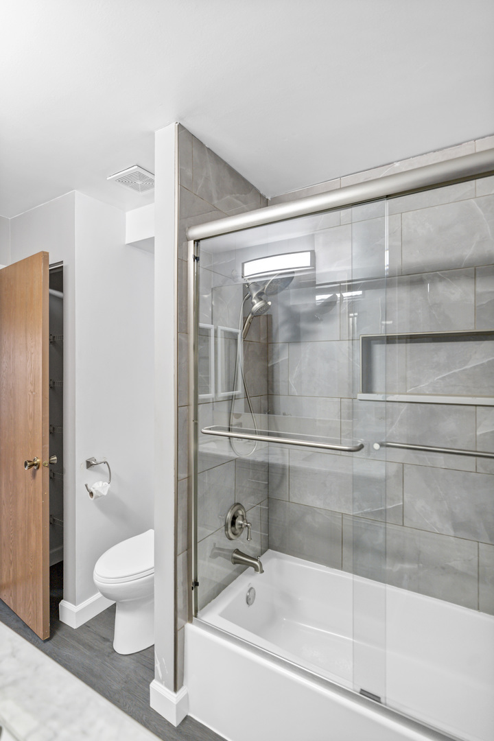 1941 Quaker Hollow Lane, Unit 1941 Streamwood, IL 60107 - Photo 9 of 13 a bathroom with a bathtub and a shower