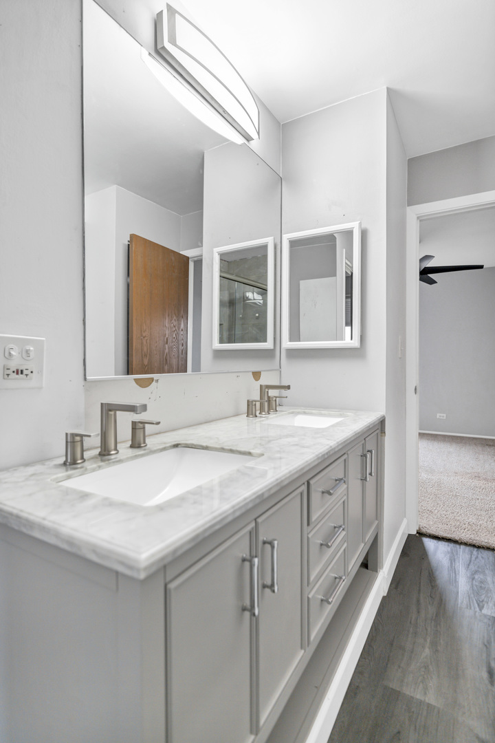 1941 Quaker Hollow Lane, Unit 1941 Streamwood, IL 60107 - Photo 10 of 13 a bathroom with double sink and a mirror