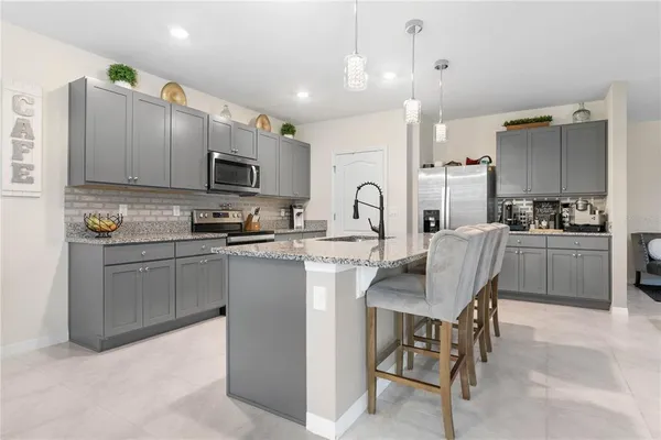 a kitchen with a sink a microwave and cabinets