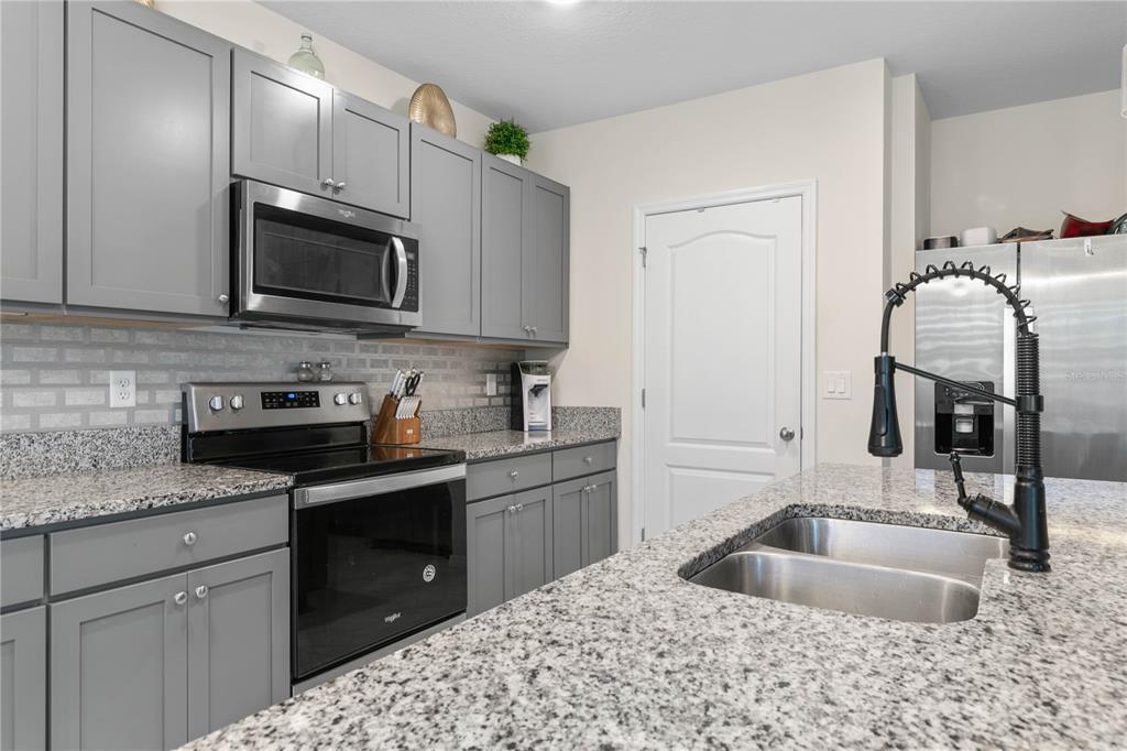 225 Sunset Point Drive Ormond Beach, FL 32174 - Photo 13 of 53 a kitchen with stainless steel appliances granite countertop a sink stove and refrigerator