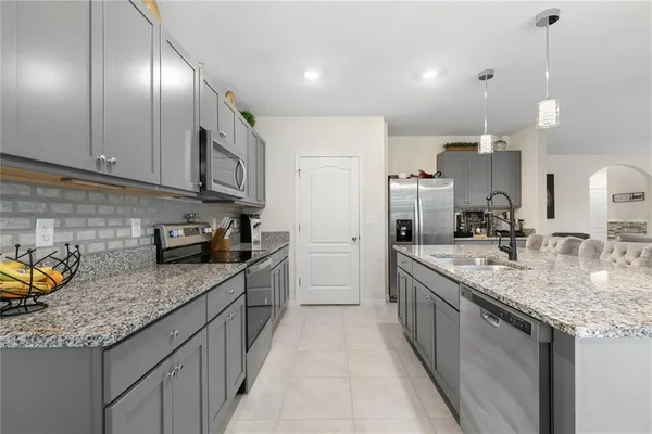 a kitchen with stainless steel appliances granite countertop a sink a stove and a refrigerator