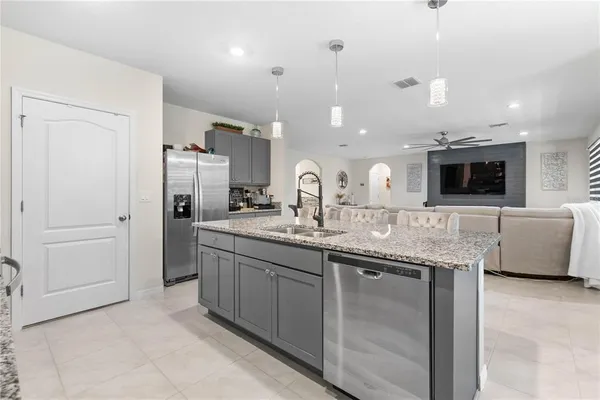 a kitchen with kitchen island granite countertop a sink and refrigerator