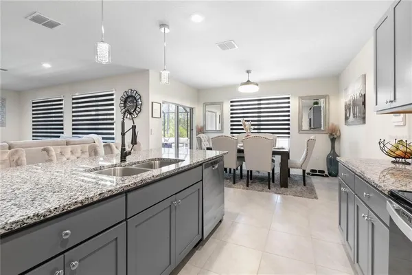 a kitchen with granite countertop sink window and white cabinets