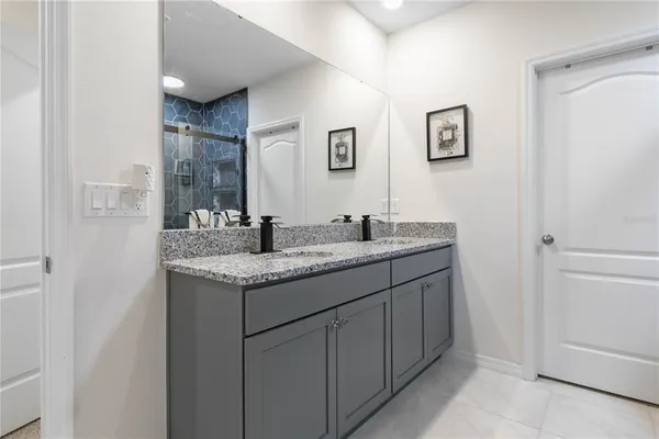a bathroom with a granite countertop sink and a mirror