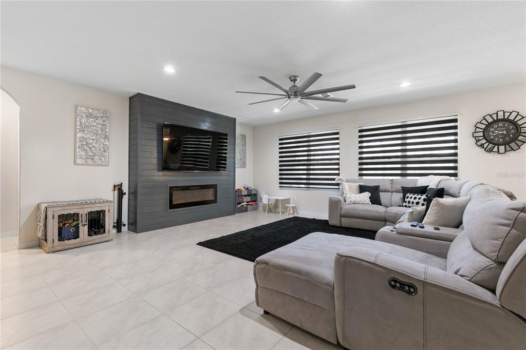 225 Sunset Point Drive Ormond Beach, FL 32174 - Photo 7 of 53 a living room with furniture a flat screen tv and a fireplace