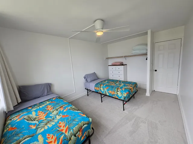 a bedroom with a bed a dresser and a chandelier