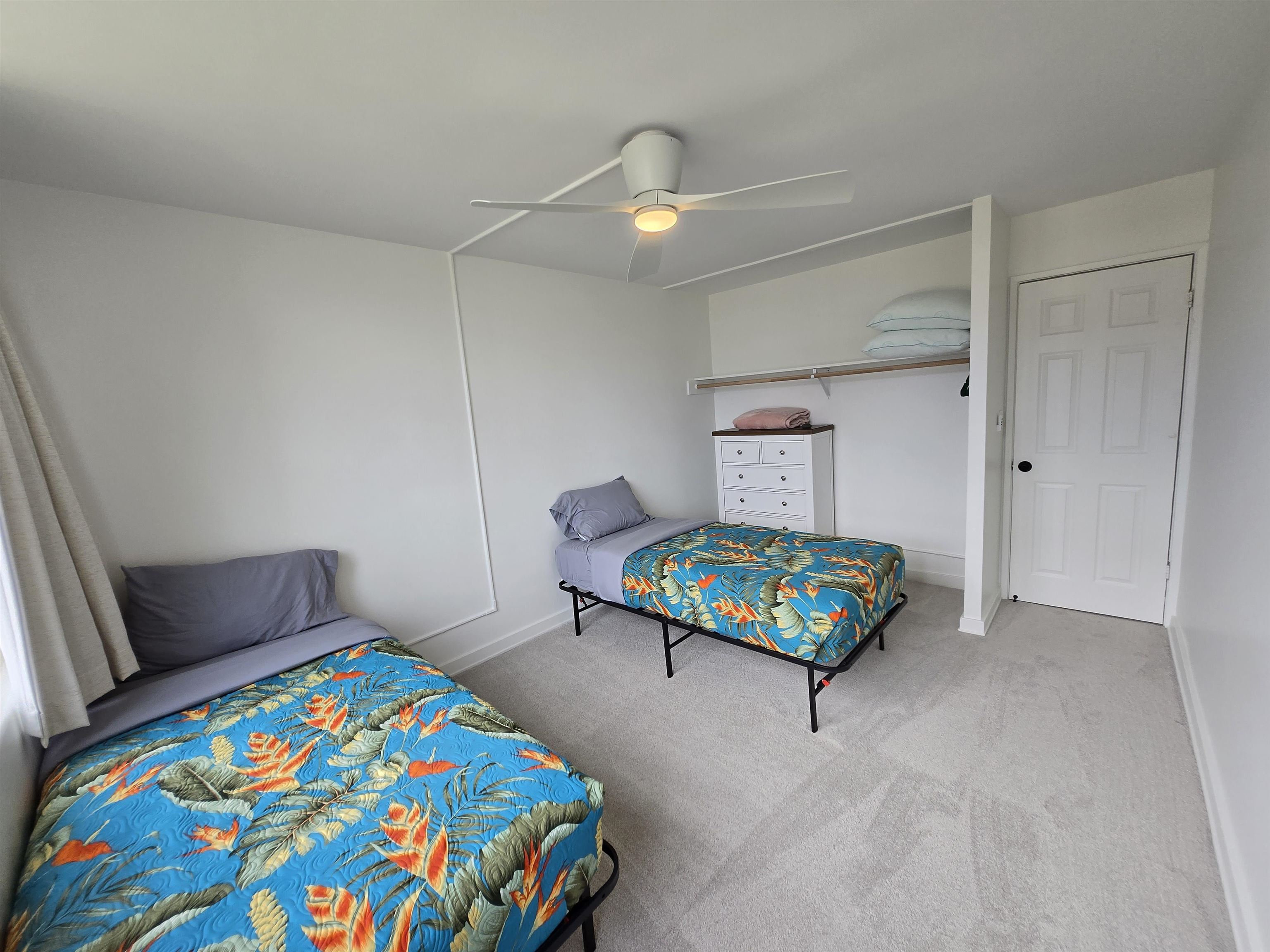 111 Kahului Beach Road, Unit B114 Kahului, HI 96732 - Photo 6 of 11 a bedroom with a bed a dresser and a chandelier