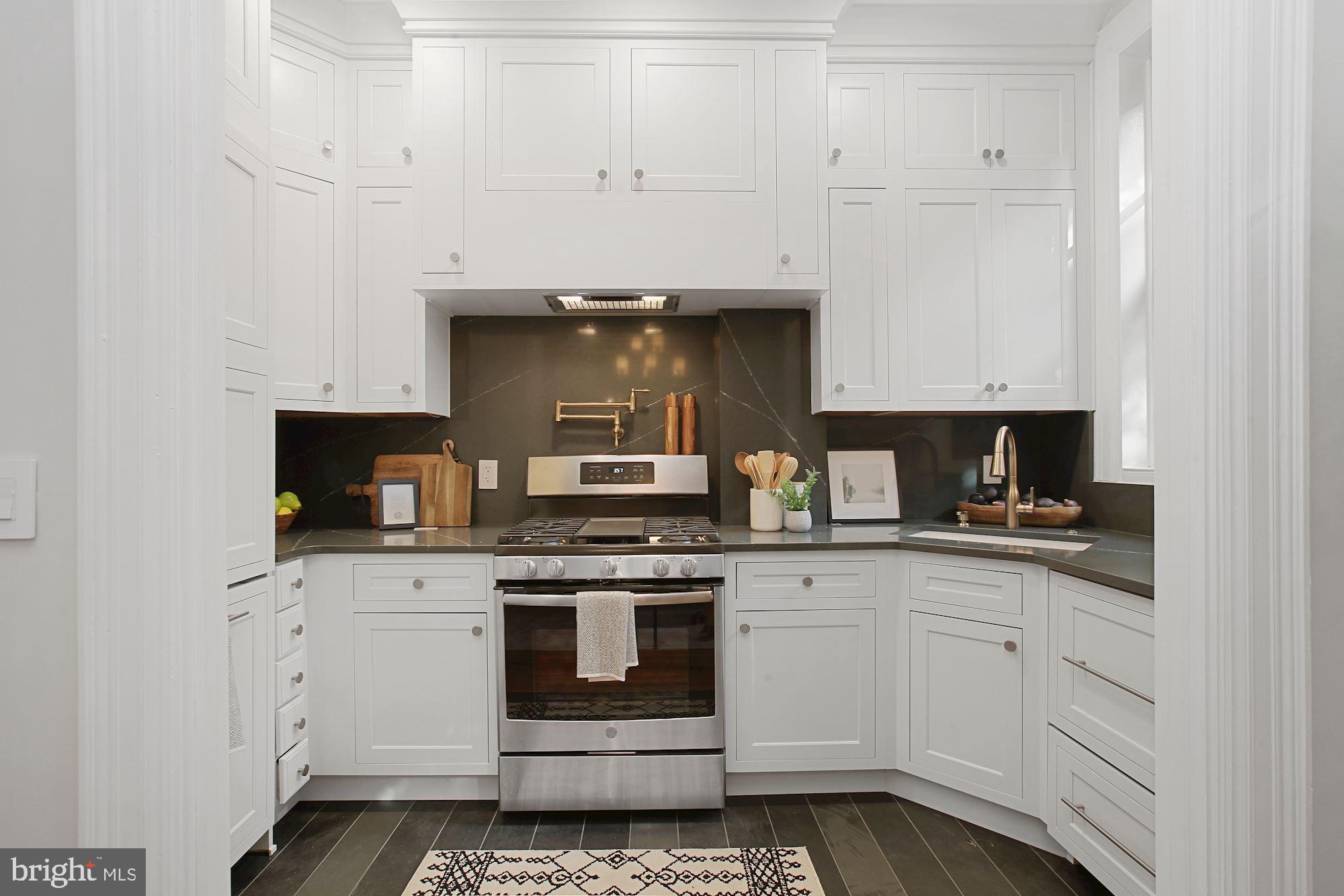 2853 Ontario Road Northwest, Unit 210 Washington, DC 20009 - Photo 13 of 28 a kitchen with white cabinets and appliances
