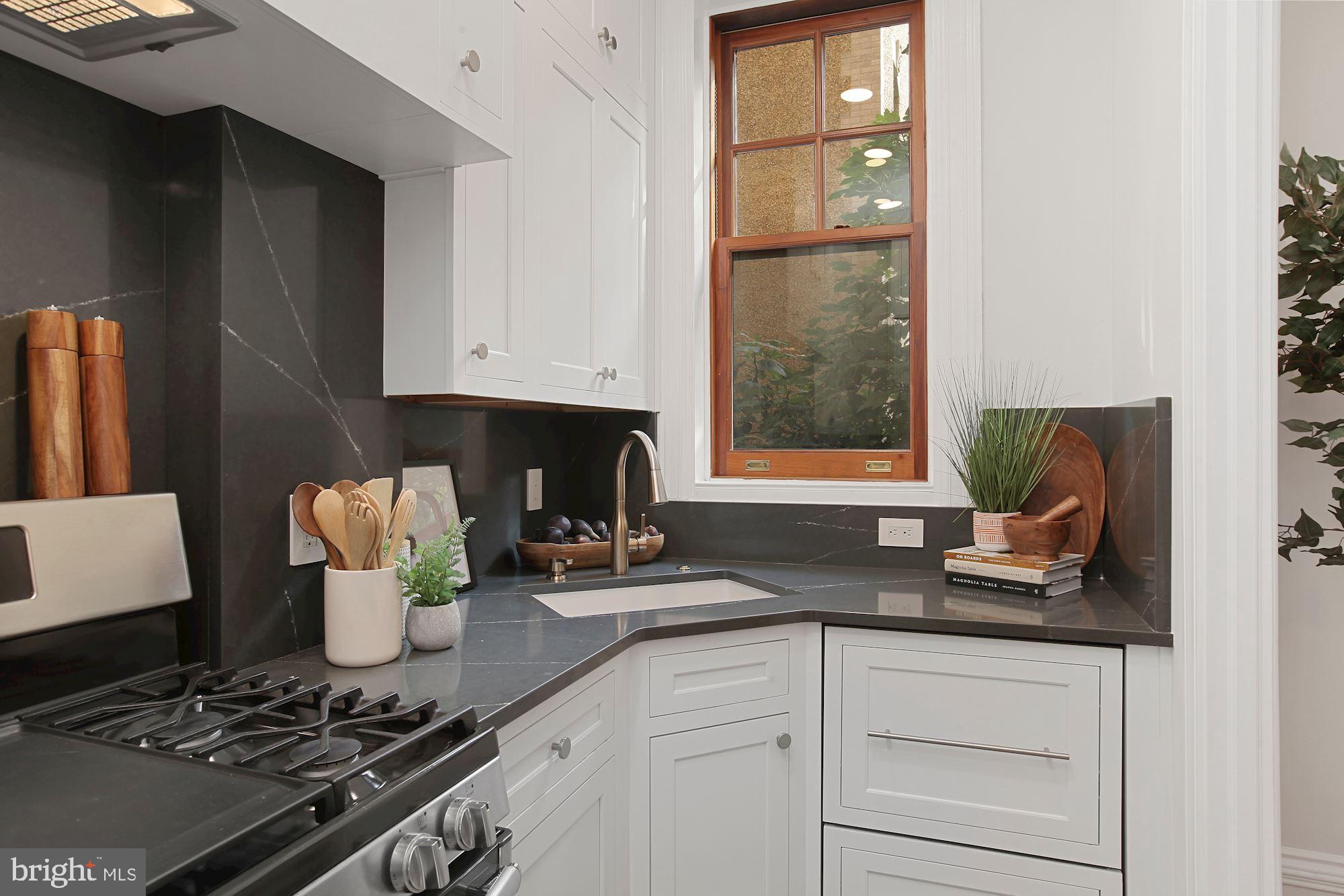 2853 Ontario Road Northwest, Unit 210 Washington, DC 20009 - Photo 14 of 28 a kitchen with stainless steel appliances granite countertop a sink stove and cabinets