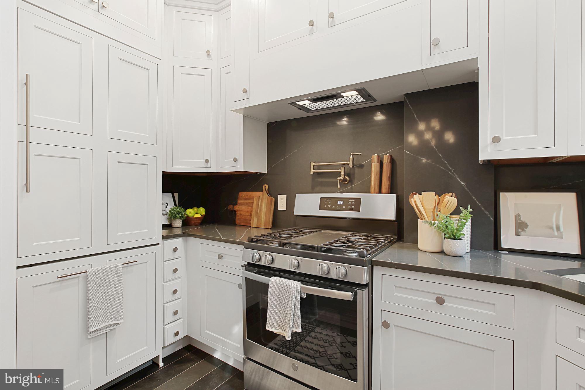2853 Ontario Road Northwest, Unit 210 Washington, DC 20009 - Photo 16 of 28 a kitchen with granite countertop white cabinets and appliances