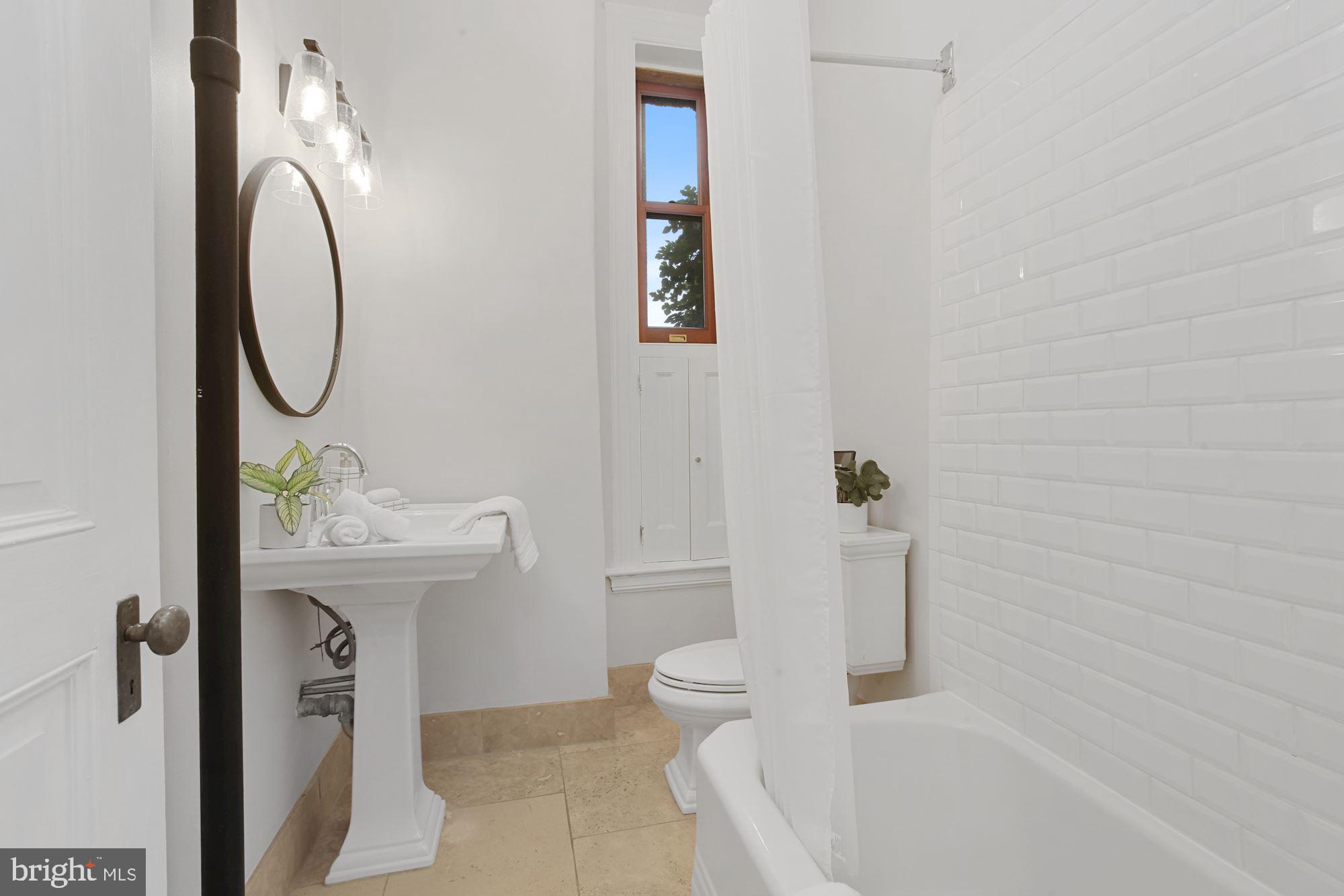 2853 Ontario Road Northwest, Unit 210 Washington, DC 20009 - Photo 17 of 28 a bathroom with a sink a toilet and shower