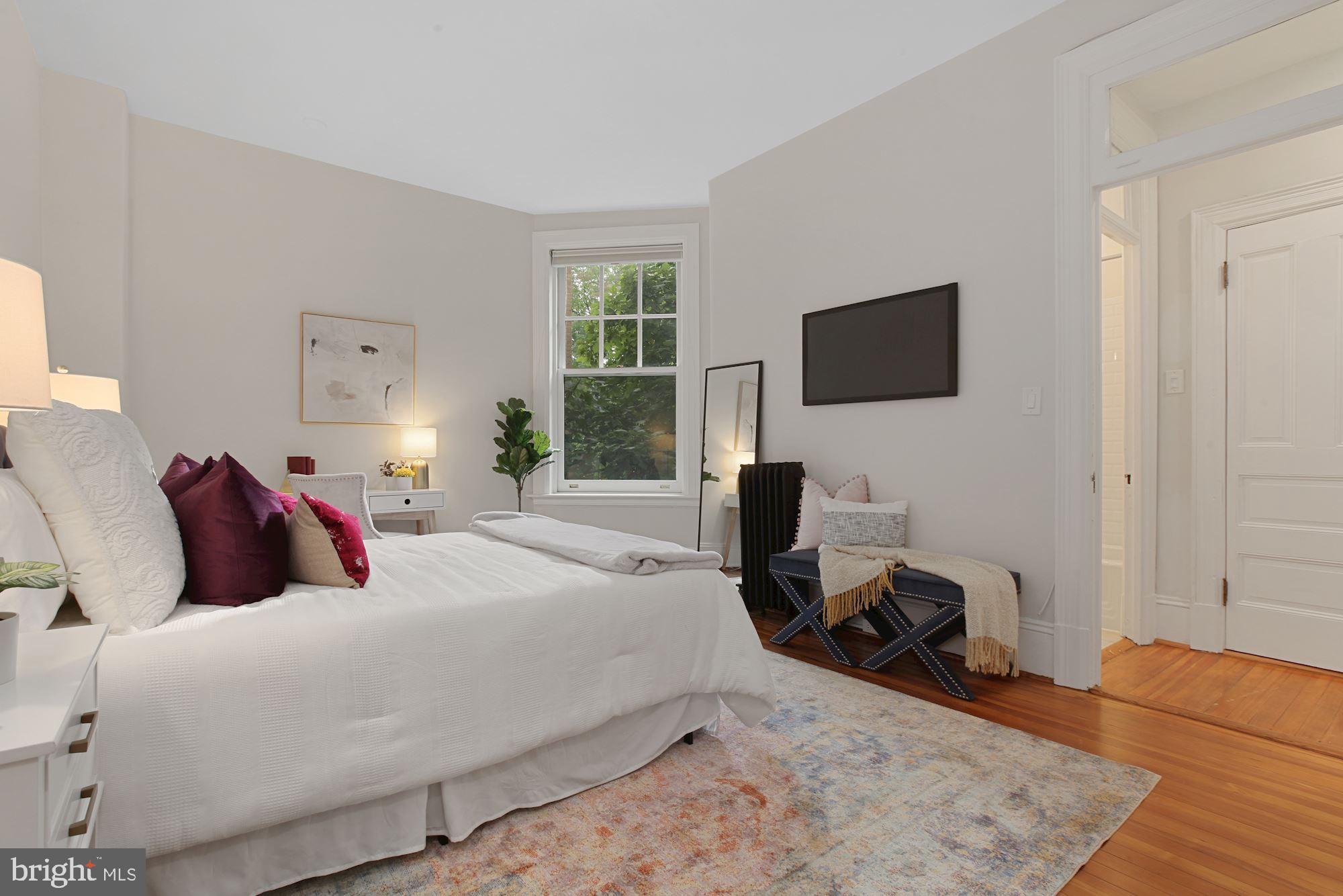 2853 Ontario Road Northwest, Unit 210 Washington, DC 20009 - Photo 19 of 28 a bedroom with a bed window and a flat screen tv