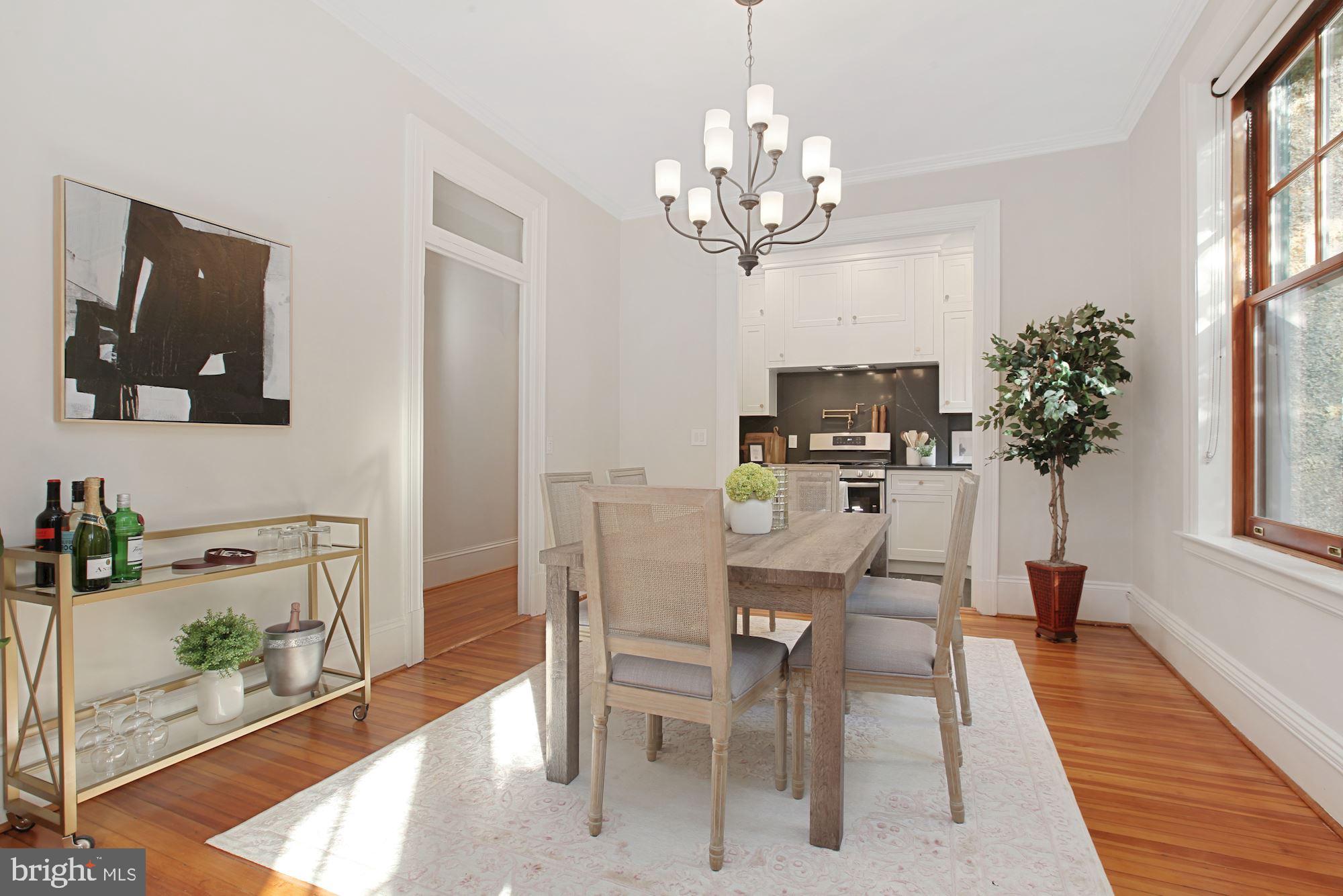 2853 Ontario Road Northwest, Unit 210 Washington, DC 20009 - Photo 9 of 28 a view of a dining room with furniture a chandelier and wooden floor