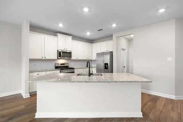 a kitchen with stainless steel appliances granite countertop a sink a refrigerator and a granite counter tops