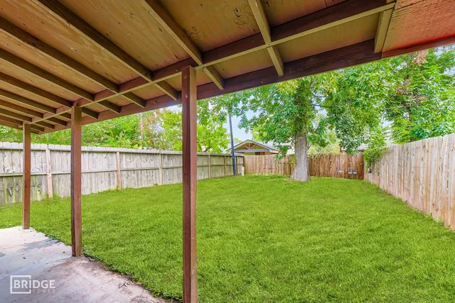 a view of a backyard with table and chairs under an umbrella