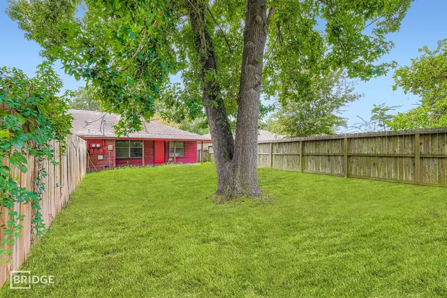 a view of a yard with a house in the background