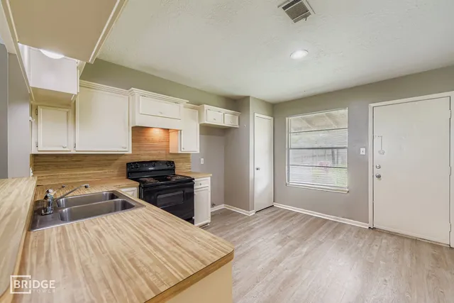 a kitchen with a refrigerator and a stove top oven