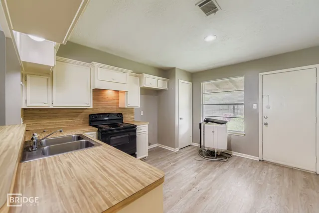 a kitchen with a refrigerator and a stove top oven